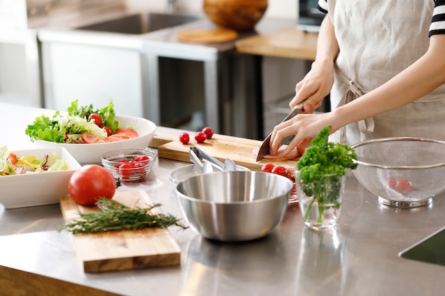 キッチンで野菜を切る人の手