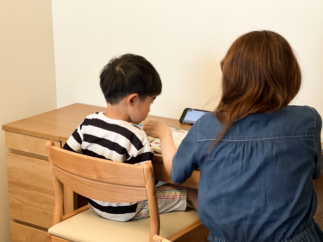 ワークスペースで母親が子どもの勉強を見守っている様子