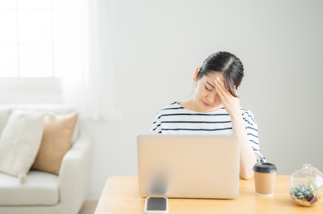 パソコンの前で悩む女性
