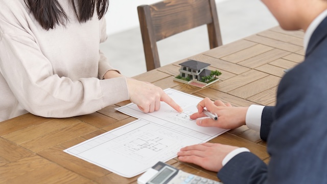 注文住宅の図面を確認しながら、間取りや資金計画について相談する様子